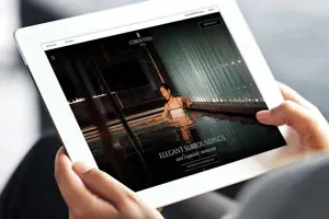 A person holding a tablet displaying Corinthia Hotels' website