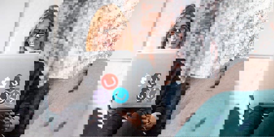 Woman reclining with a Mac laptop covered in Umbraco stickers