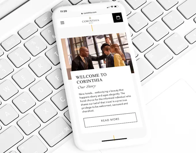 A phone displaying the frontpage of the Corinthia Hotels' website