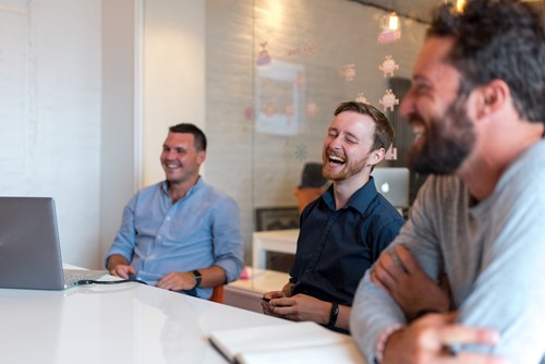 3 men smilling in a meeting