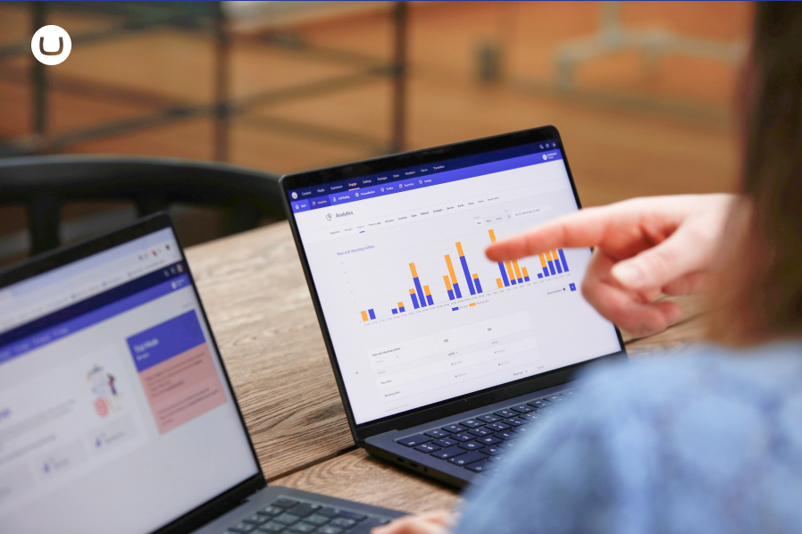 Analyics dashboard on a laptop. Finger pointing on the graph