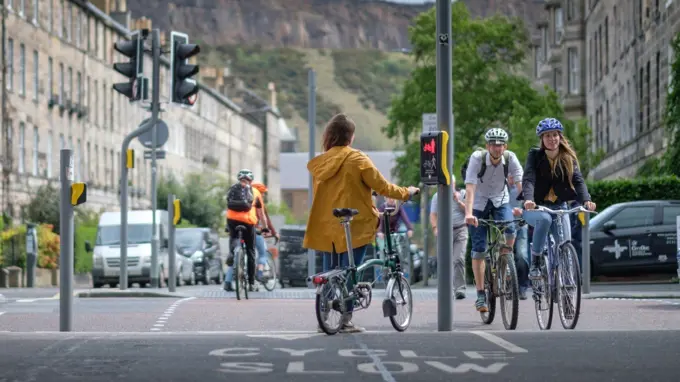 A Woman Standing At Traffic Lights
