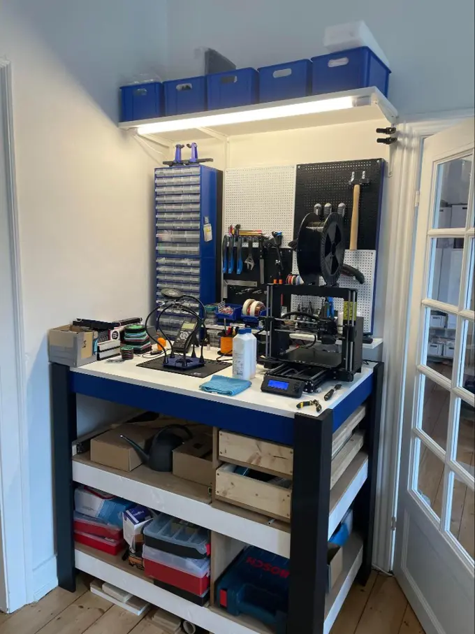 An organized work bench in an apartment next to a white door