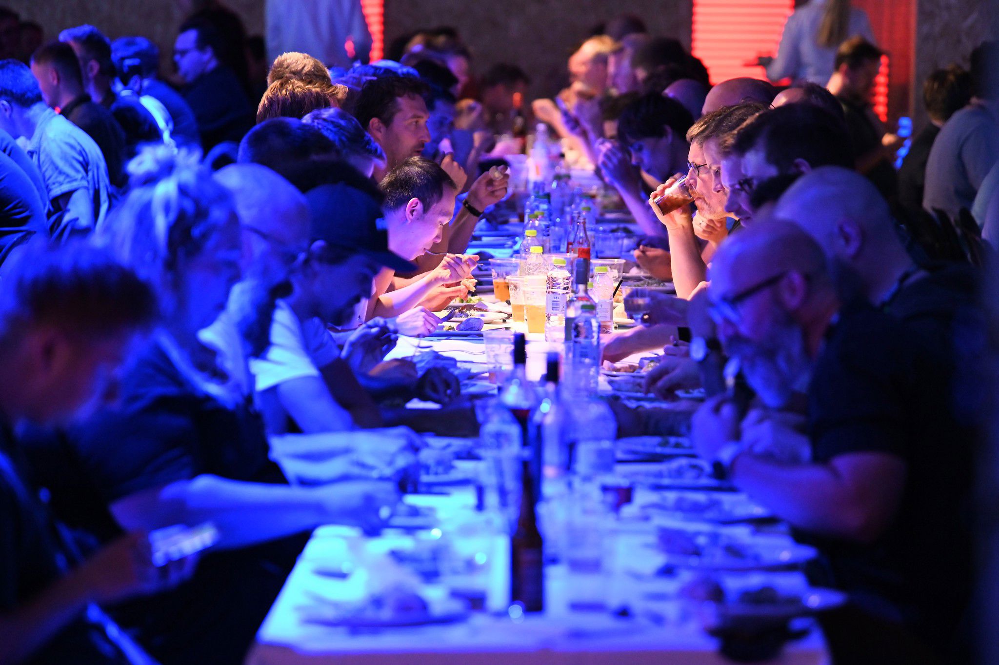 A group of people sitting at a long table eating dinner