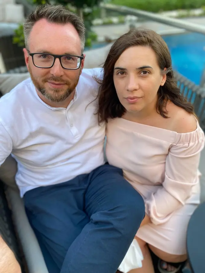 Adrian and his wife in front of a pool