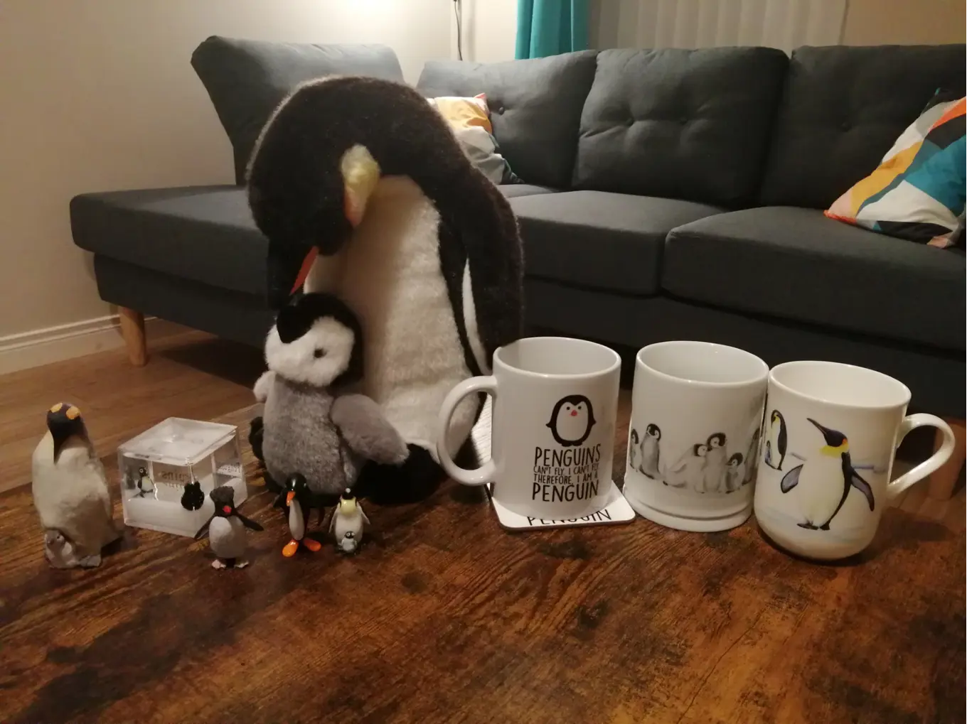 A row of penguin-related items, from a snow cube, teddies, mugs and figures.