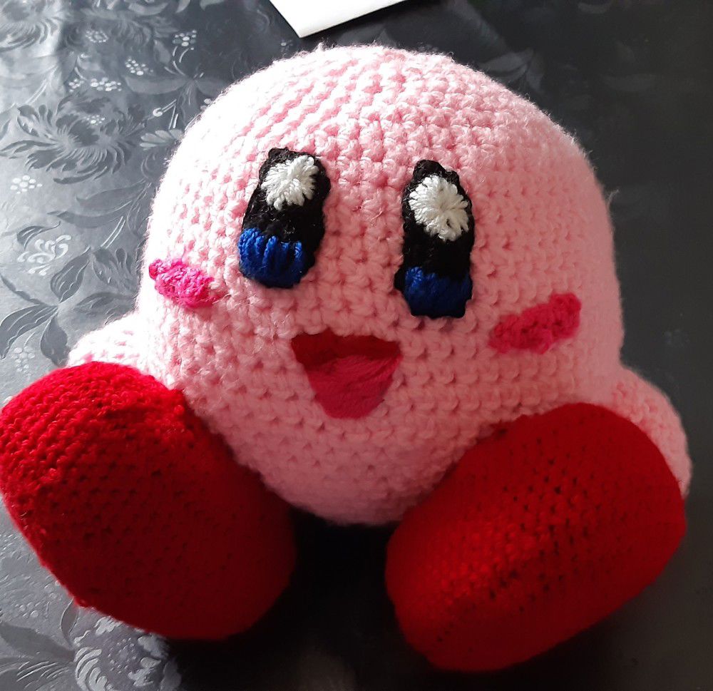 a crocheted version of kirby the animated character