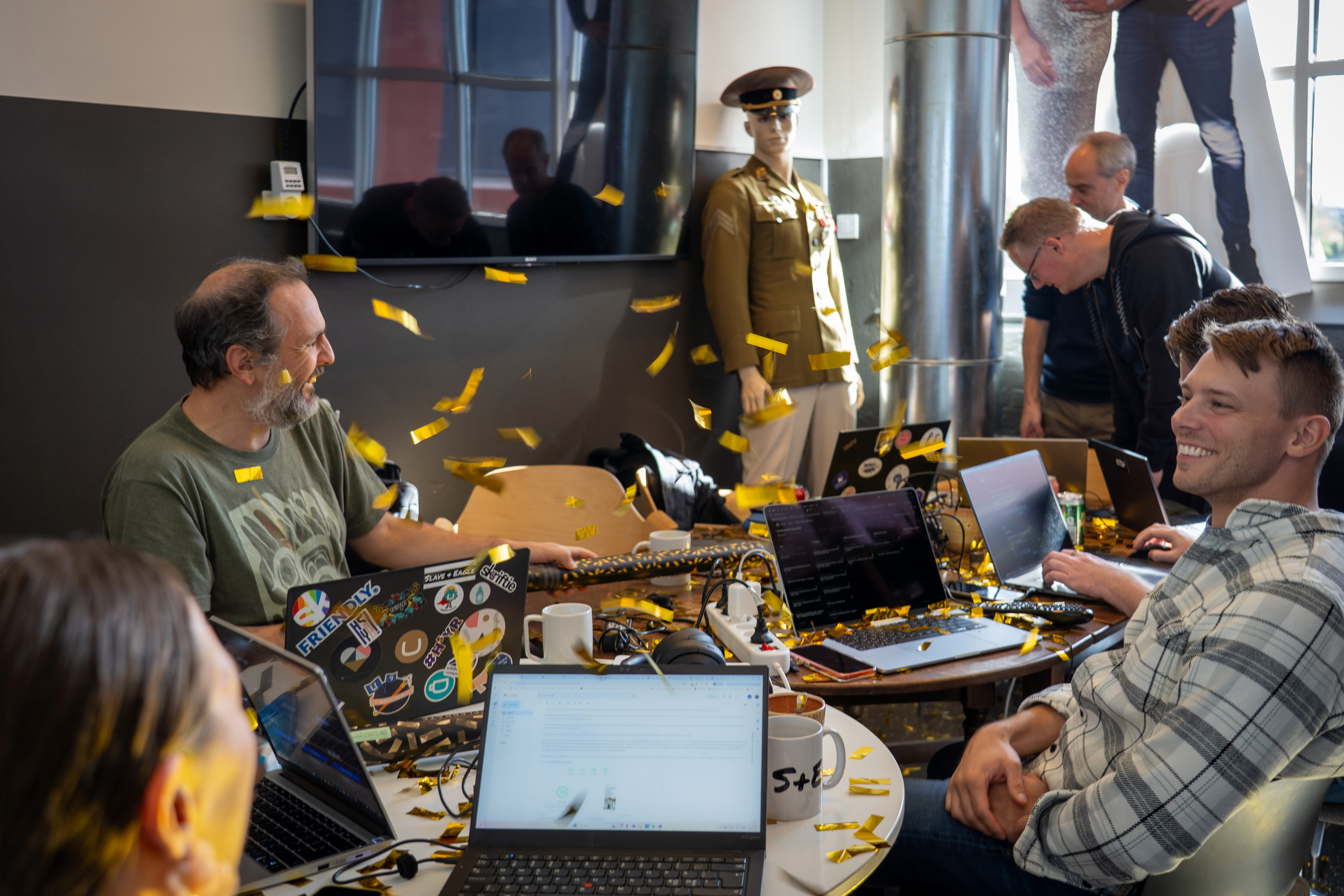 People sitting around a table with flying confetti