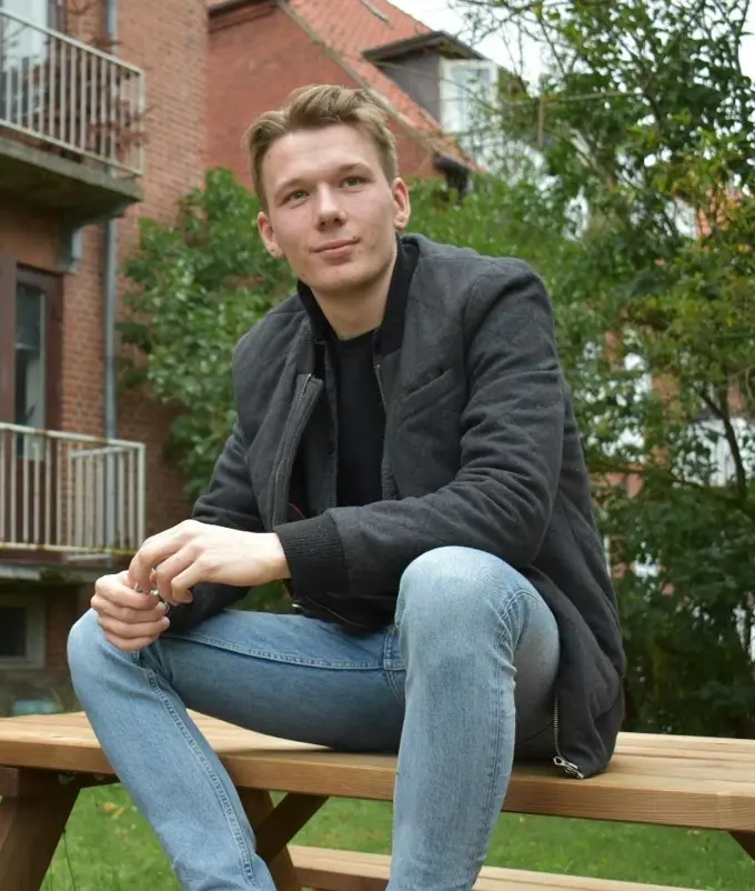 Jesper Moller Jensen sitting on a picnic table looking contemplative