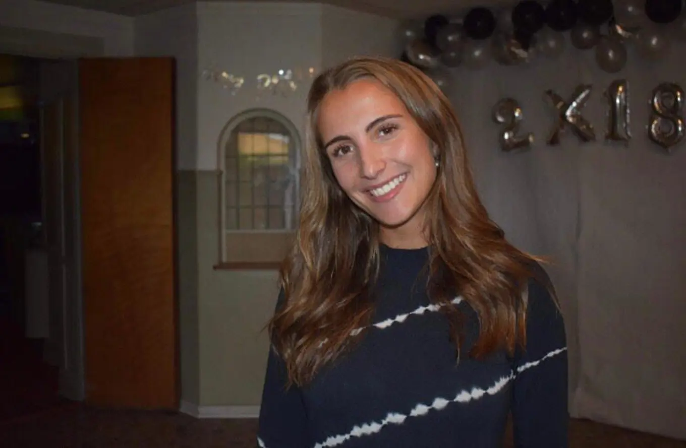 Patricia smiling with party balloons in the background