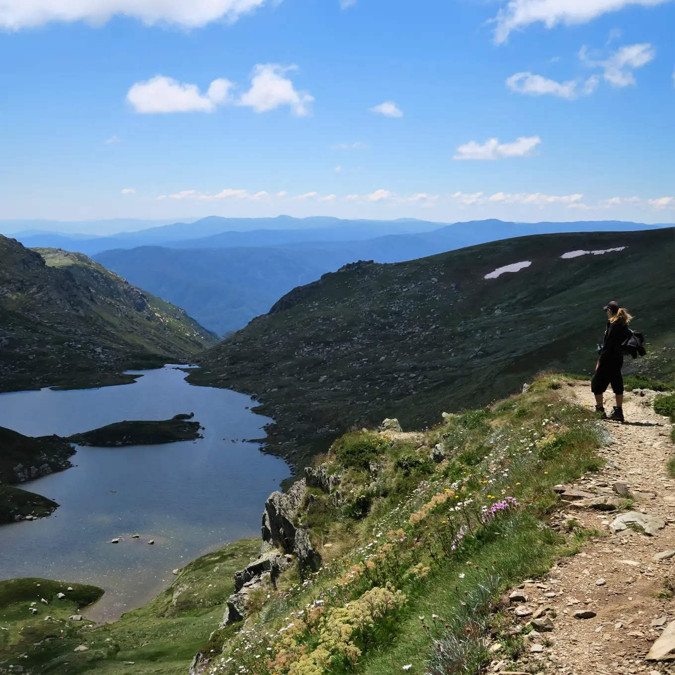 A woman looking out on top of a mountain