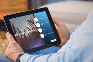 Person holding a tablet showing “ADVANCE YOUR FARM” website with navigation circles and a “RAVEN” logo
