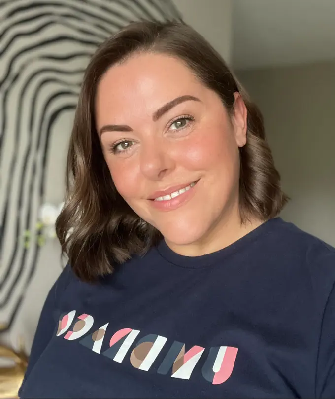 Profile Picture of Lucy Brailsford wearing a dark blue tshirt with a white, pink, brown and blue Umbraco logo on it