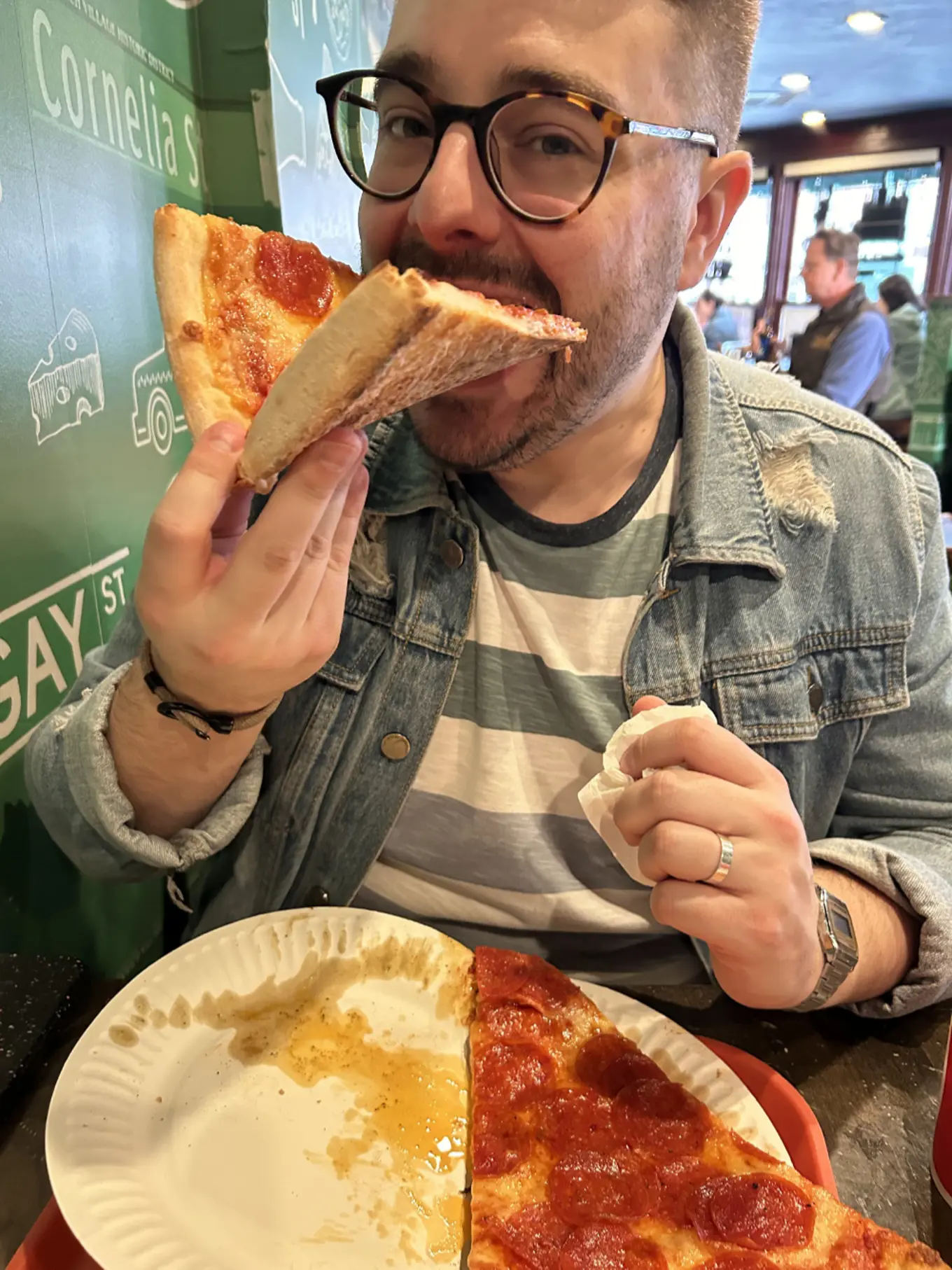 An image of Rick Butterfield tucking into a huge slice of New York pepperoni pizza, while visiting NYC. 