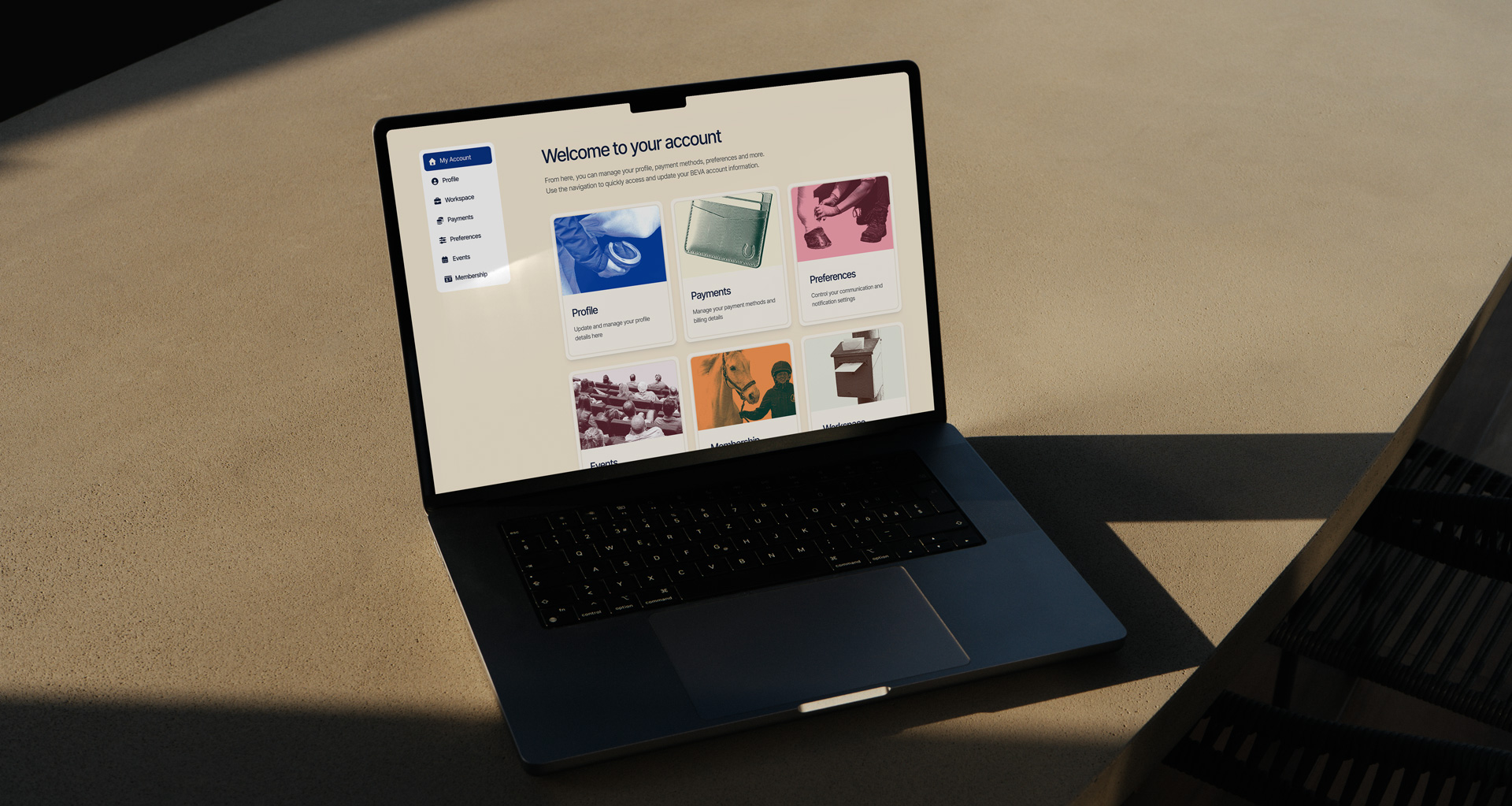 Laptop on desk displaying “Welcome to your account” with profile, payments, preferences, and events tiles