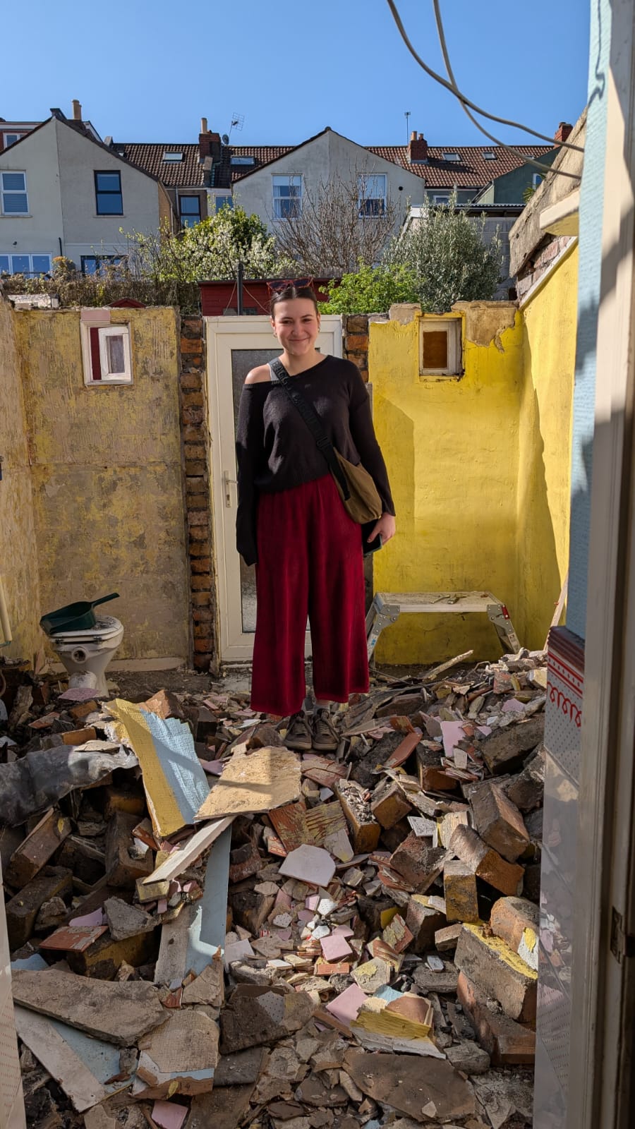 Georgina in a pile of rubble during a home renovation