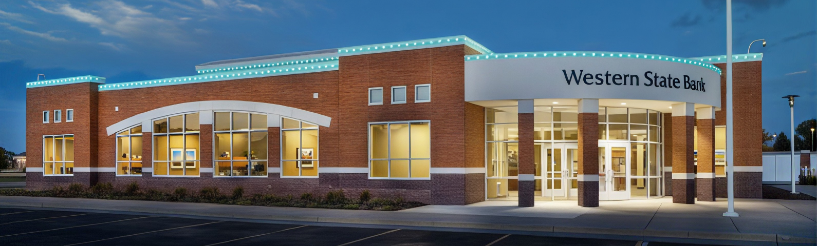 Western State Bank building facade with illuminated blue sign and glass entrance under twilight sky