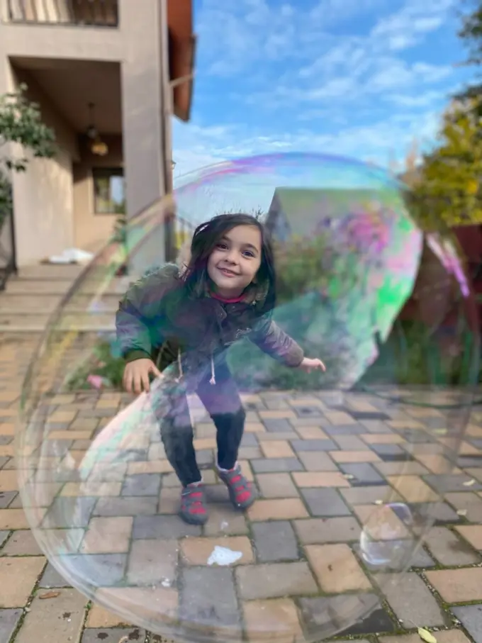 Adrian's daughter looking at the camera through a bubble