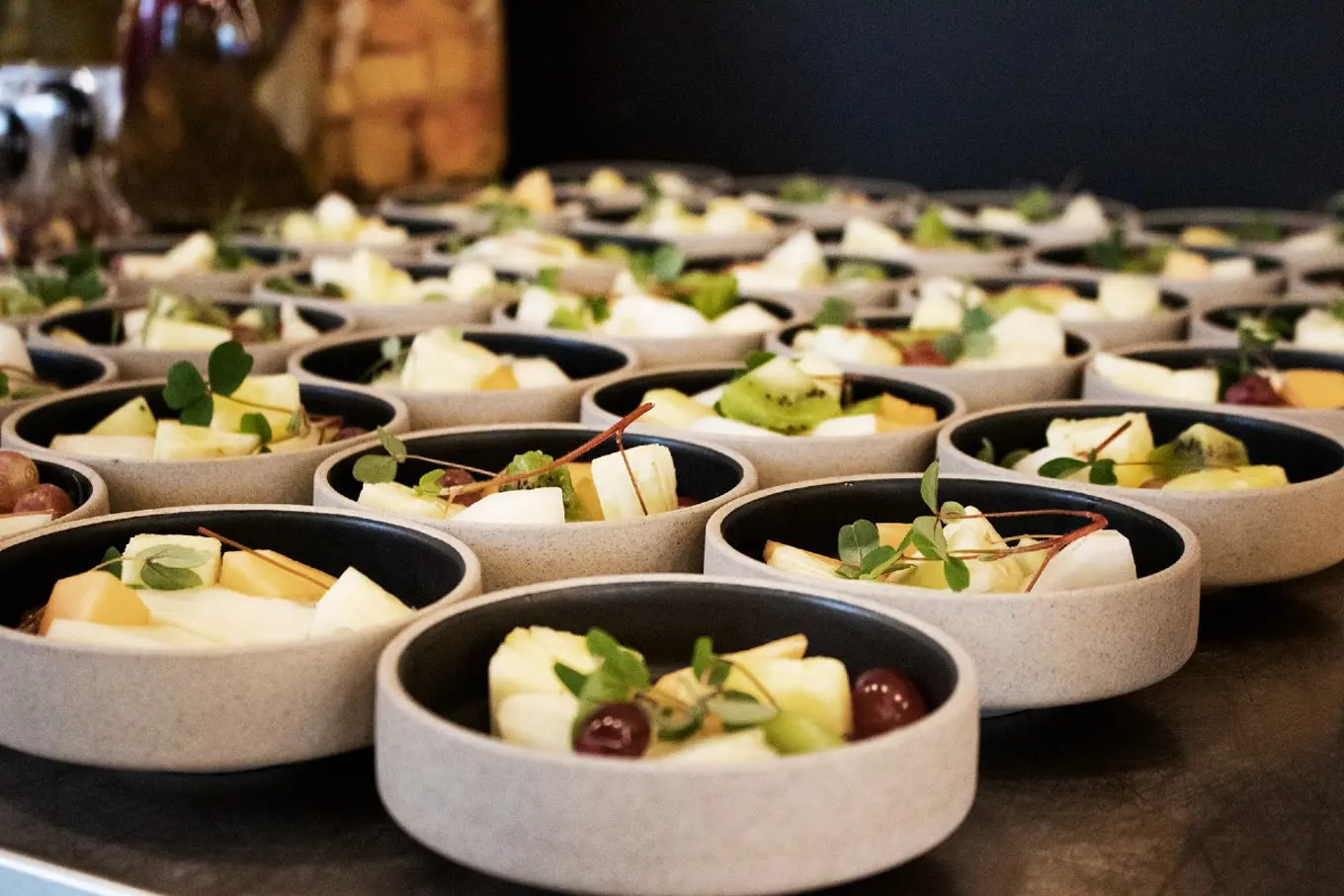 A table is filled with bowls with pleasantly presented fruit