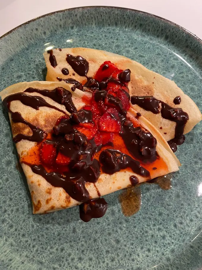 French crepes with melted chocolate and fresh strawberry jam