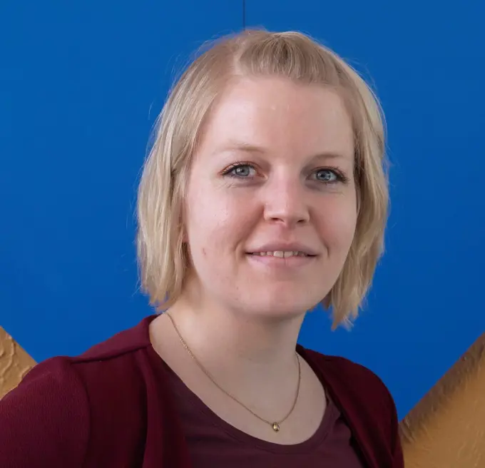 Jette Moeller Jensen, a white woman with short blonde hair, headshot against a blue background