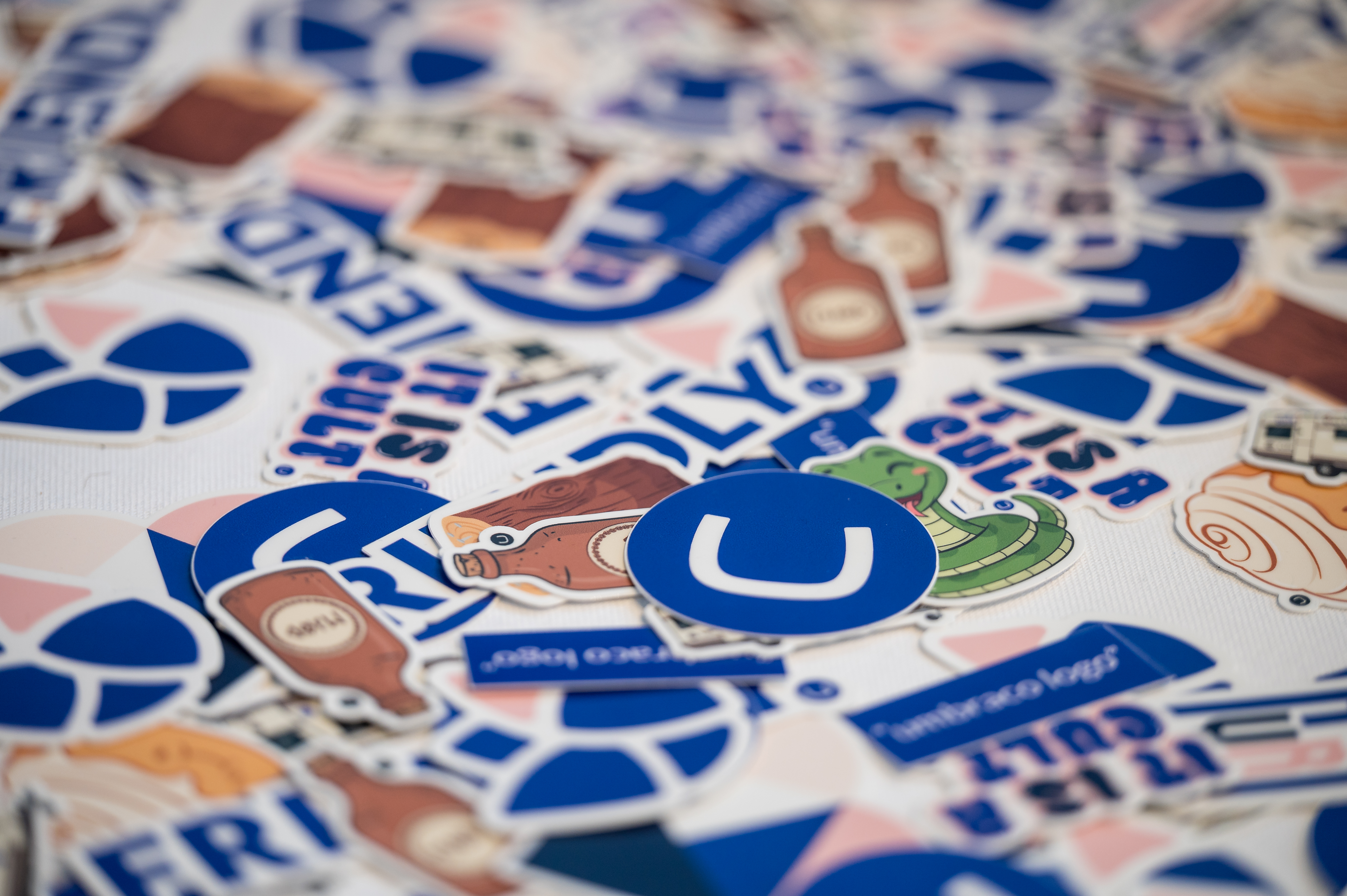 Assorted trading cards and sticker-like illustrations with a large blue “U” and a cartoon character.