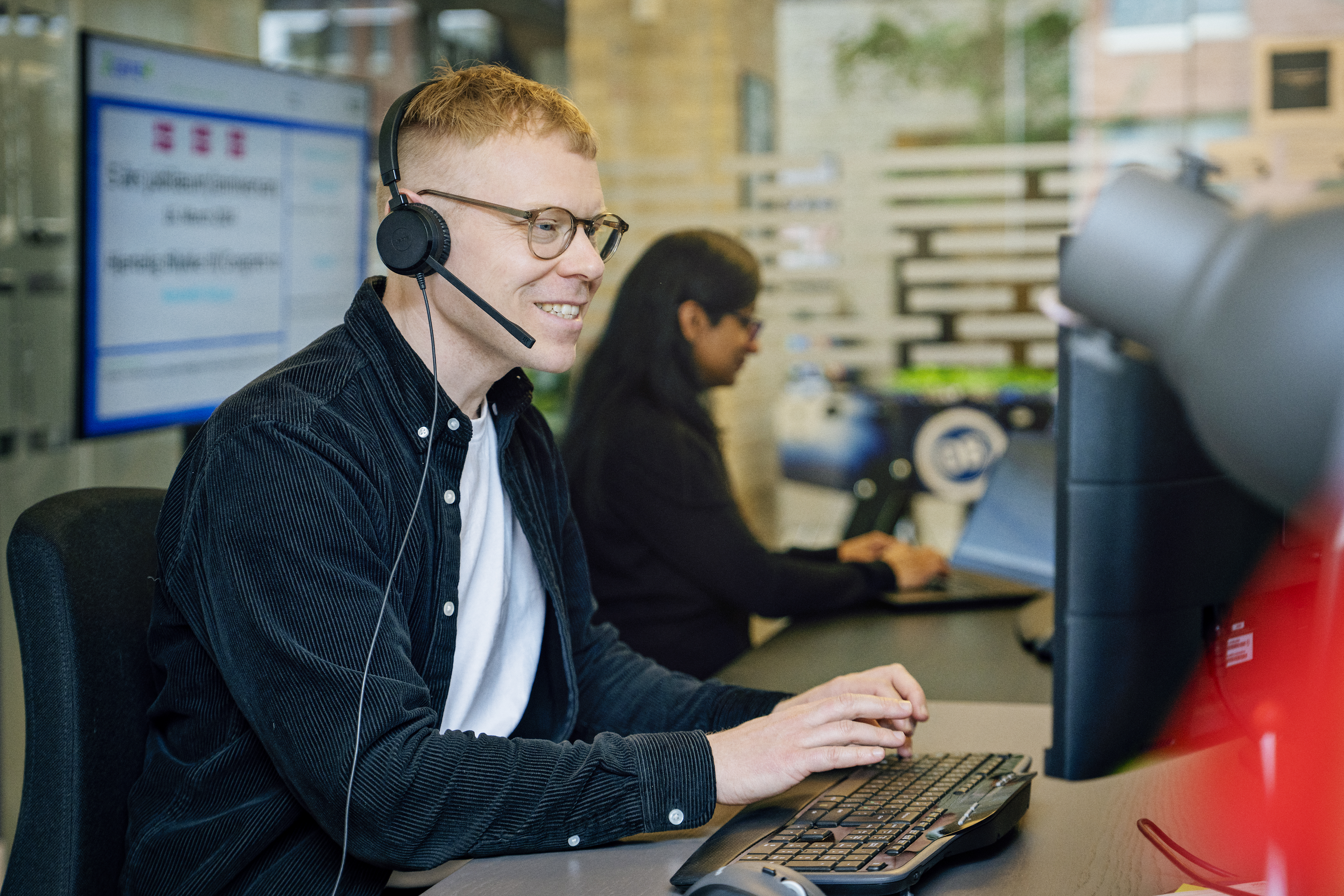 Umbraco co-worker in front of a computer, wearing a headset